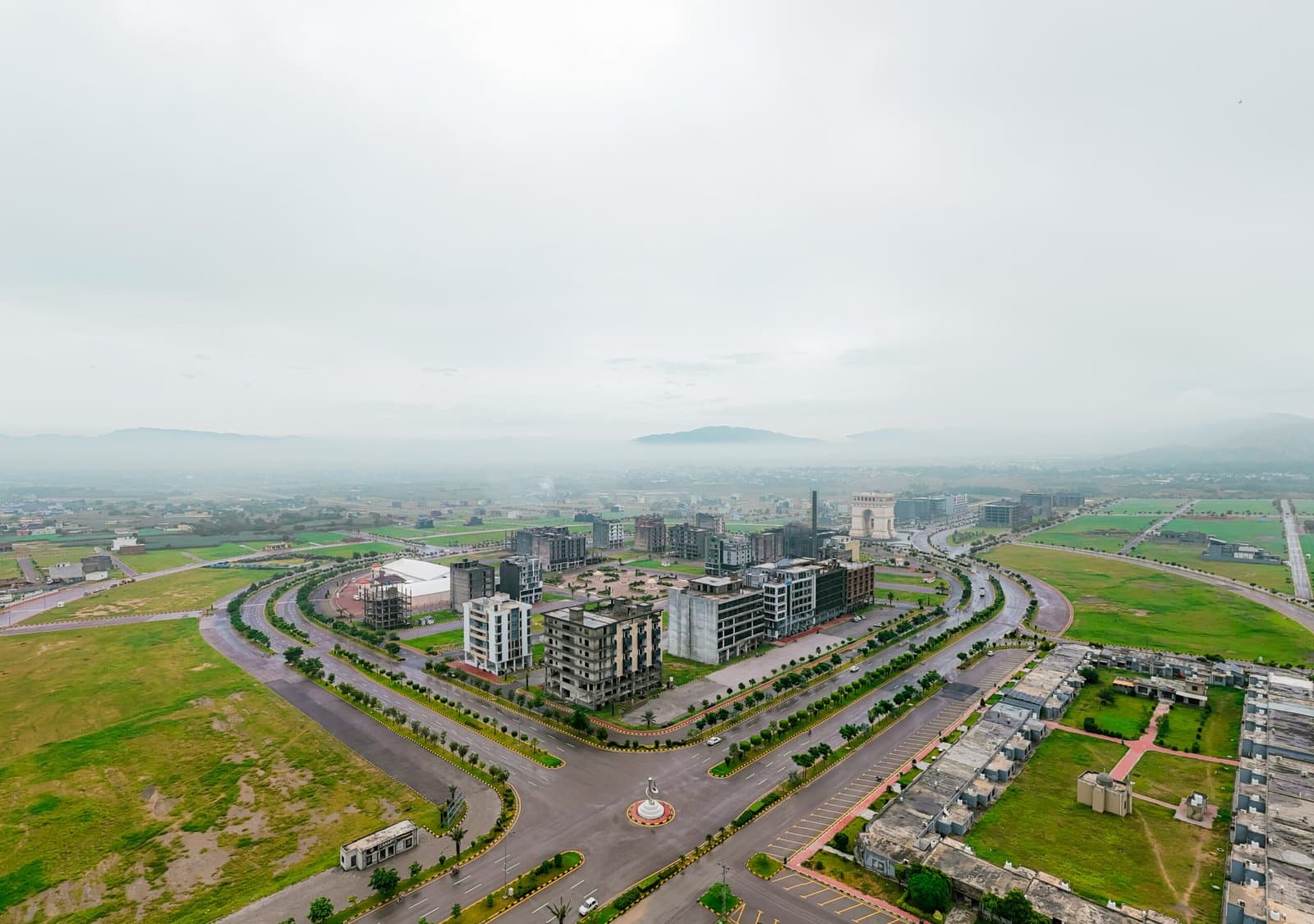 Aerial view of Faisal Hills with the Arc monument and Grand Jamia Mosque, facing the Margalla Hills