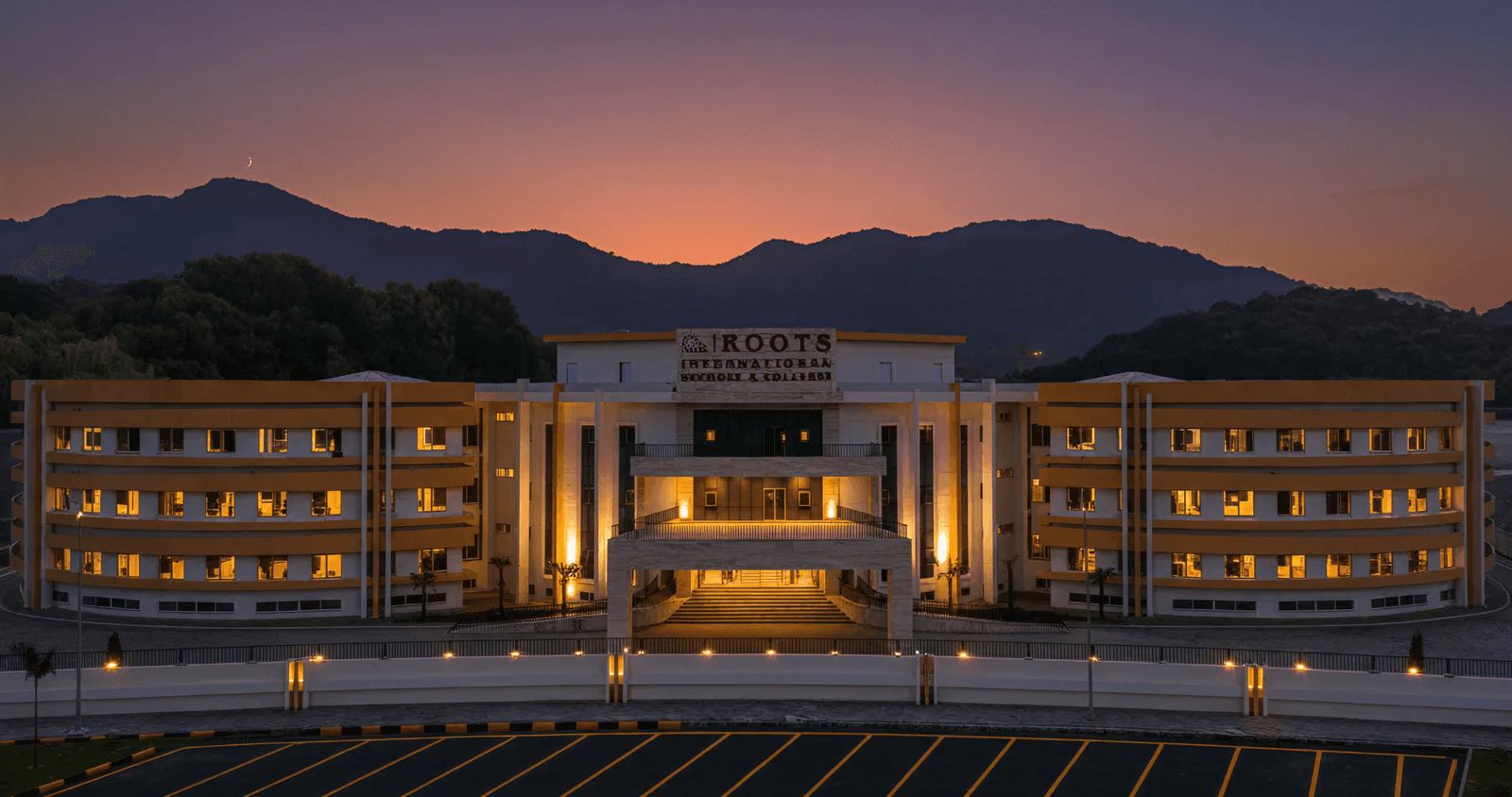 Roots International Schools campus at dusk with the Margalla Hills behind